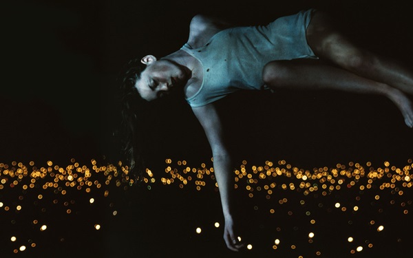 One of Bill Henson's portraits, depicting a girl who appears to be floating above a field of lights