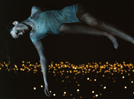 One of Bill Henson's portraits, depicting a girl who appears to be floating above a field of lights