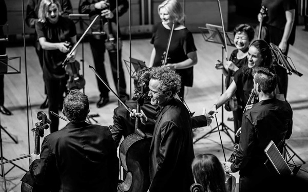 Members of the ACO smiling onstage after a performance