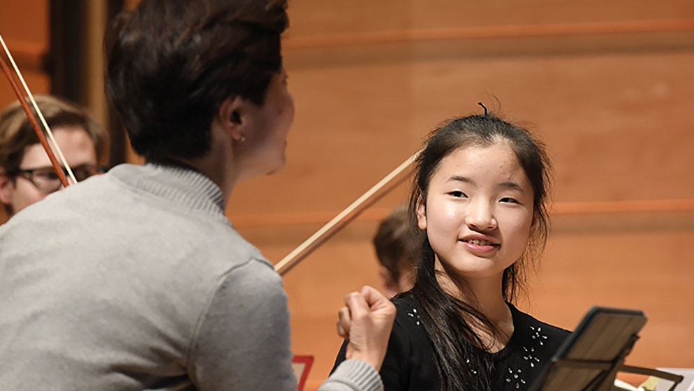Violinist Emily Su taking direction from Aiko Goto