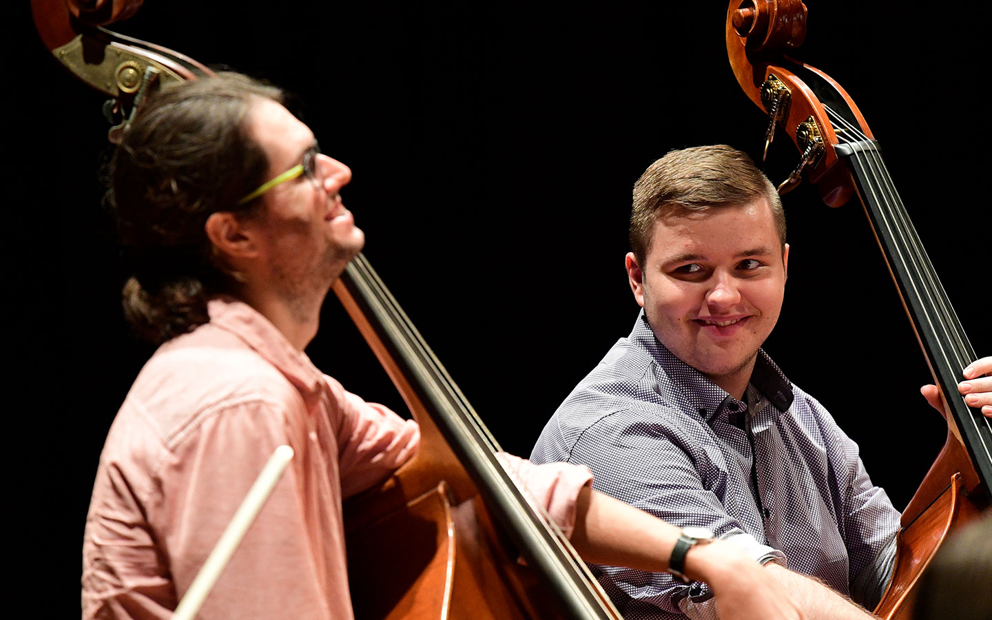 A school student being mentored on the double bass