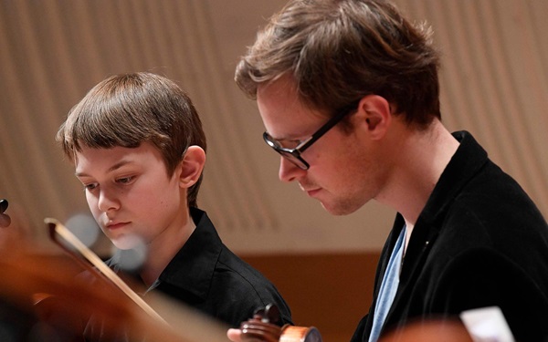 An ACO musician mentoring a young strings player
