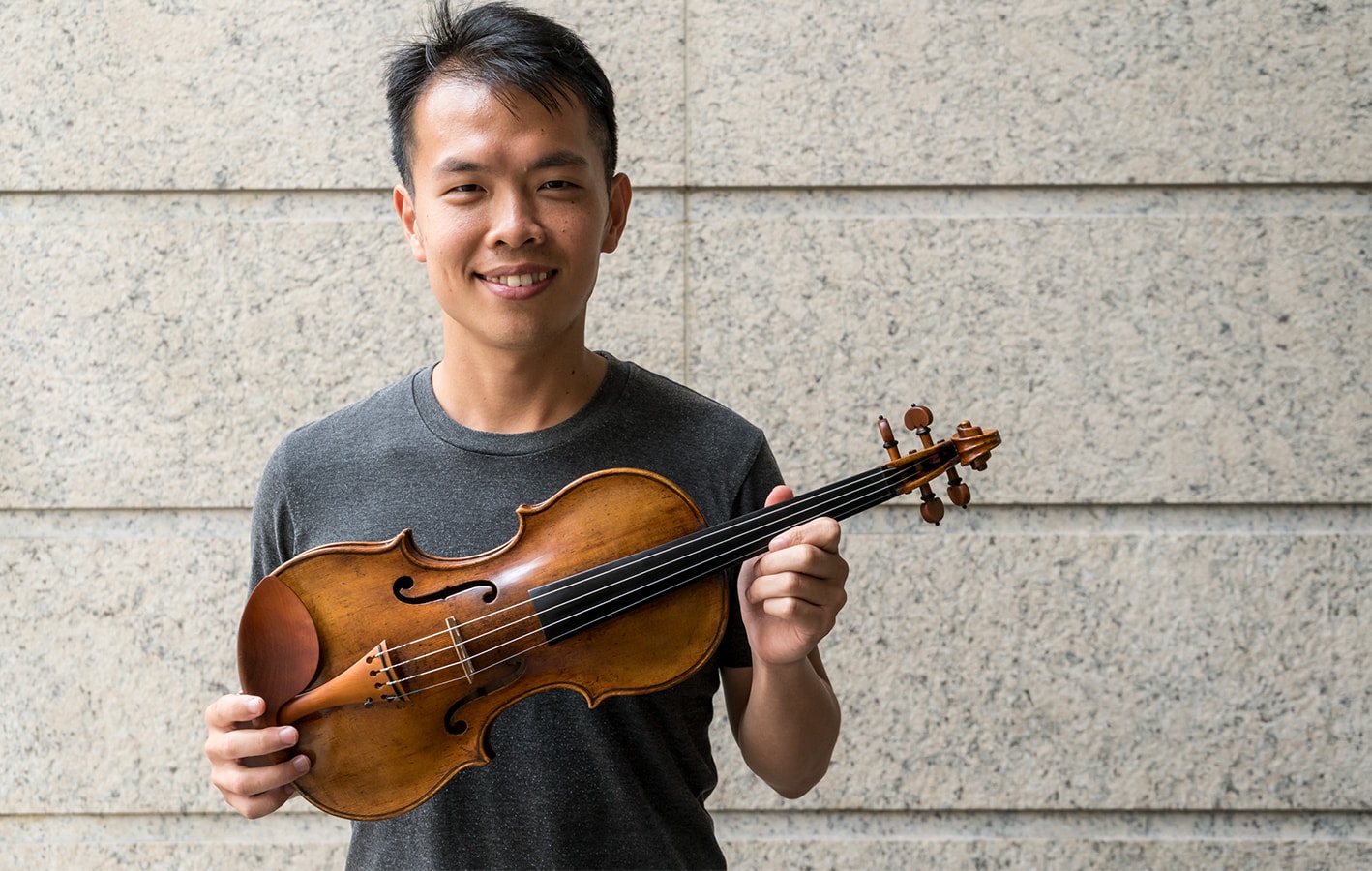 Ike See holding the 1590 Brothers Amati Violin owned by the ACO Instrument Fund
