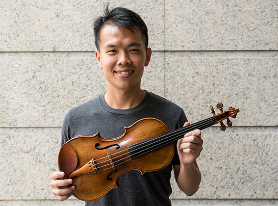 Ike See holding the ACO Instrument Fund's 1590 Brothers Amati Violin