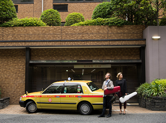 ACO Artistic Director Richard Tognetti and Principal Violin Satu Vänskä standing in front of a taxi in Japan