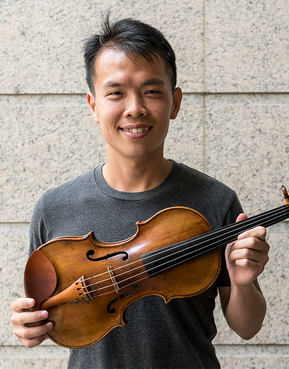 Ike See holding the ACO Instrument Fund's 1590 Brothers Amati Violin